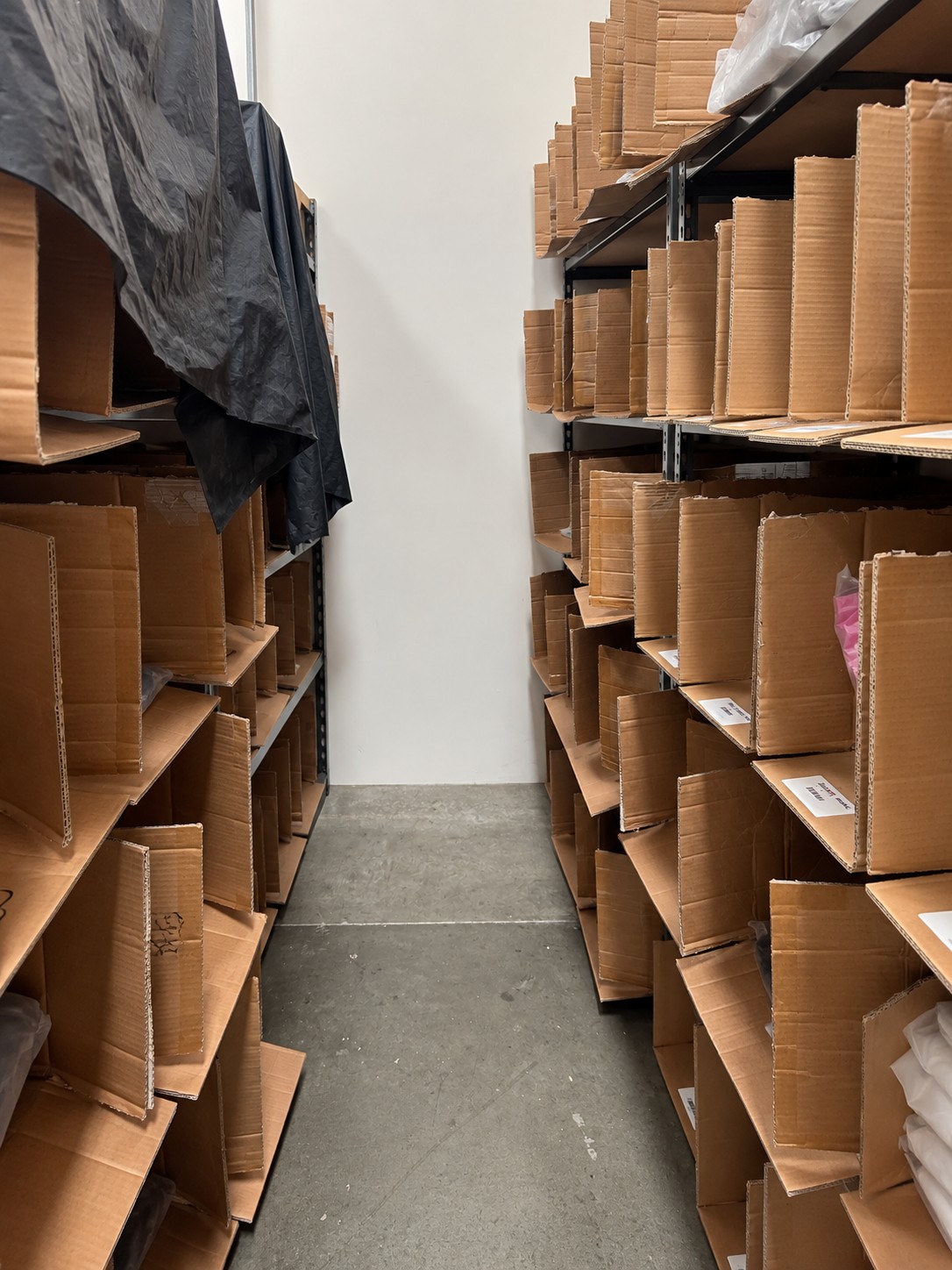 Cardboard storage bins lined up along the shelving aisles at the Stack warehouse in Brea, California
